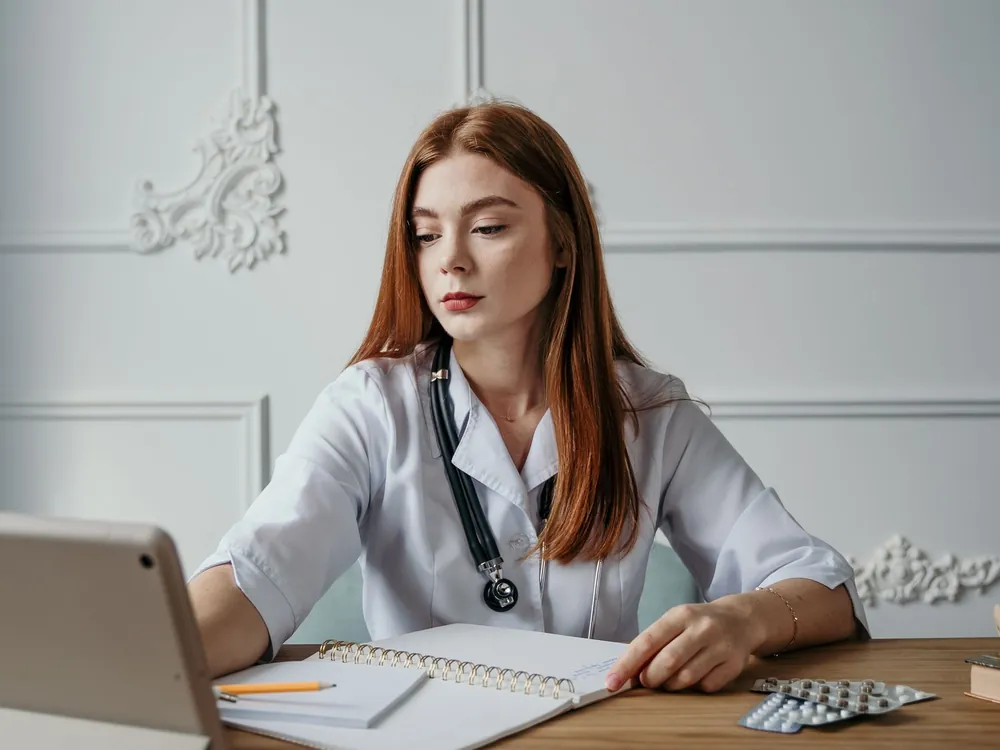 Doctor using a laptop at a clinic desk