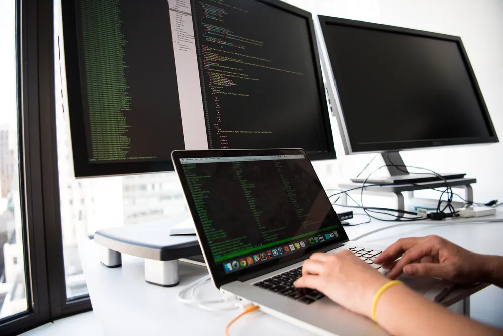 IT professional typing code on a laptop